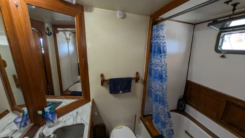 Slide: The Image of Bathroom interior of 1982 Monk 36 boat with wooden accents and blue shower curtain. - 41