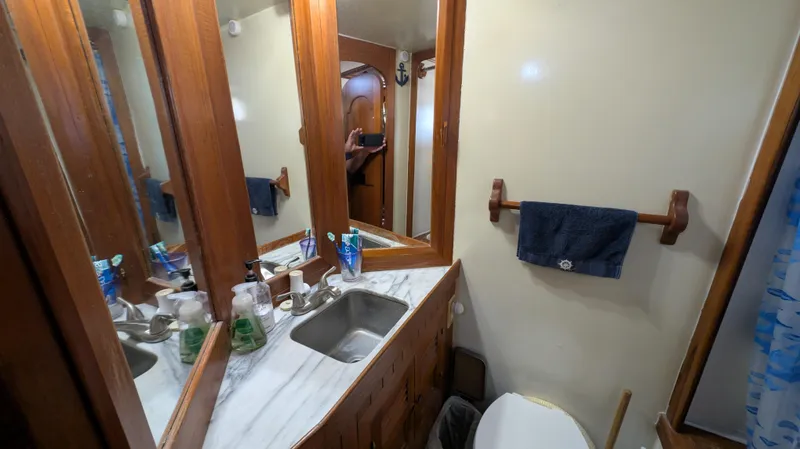 Slide: The Image of Bathroom interior of 1982 Monk 36 boat with wooden accents and marble countertop. - 44