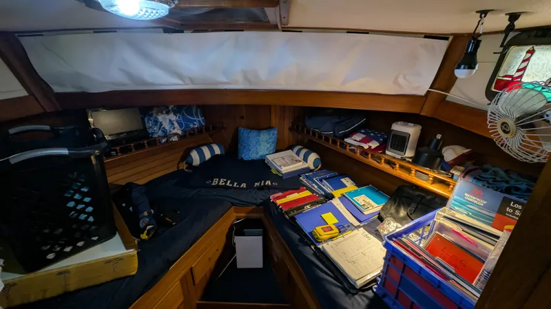 Slide: The Image of Cozy cabin interior of 1982 Monk 36 boat with books, fan, and nautical decor. - 46