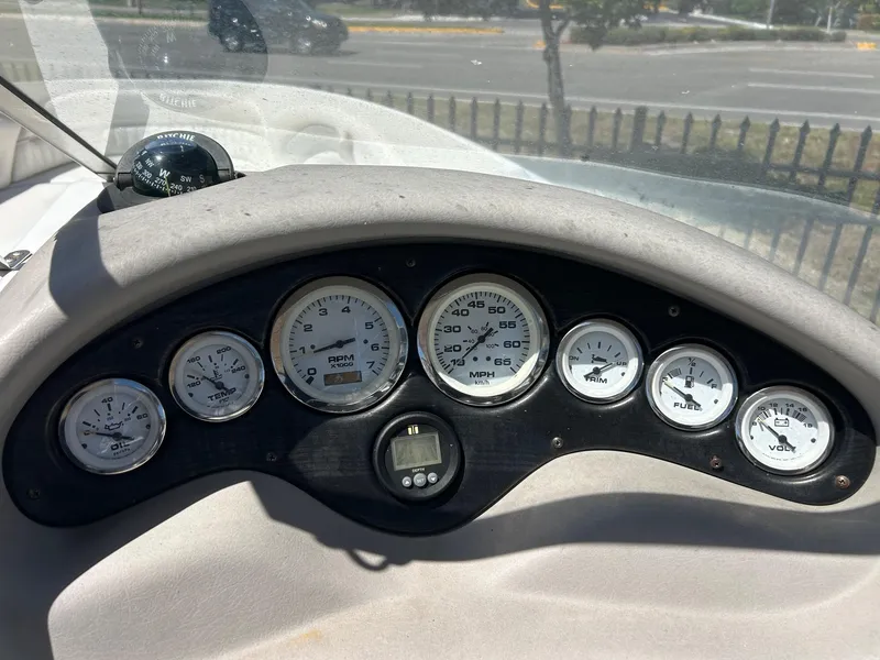 Slide: The Image of Dashboard of a 2003 Stingray 240 LR boat with gauges and compass. - 13