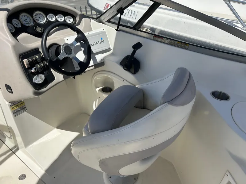 Slide: The Image of 2003 Stingray 240 LR boat cockpit with steering wheel and control panel. - 16