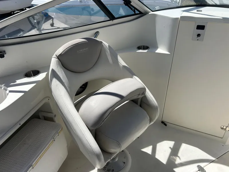 Slide: The Image of 2003 Stingray 240 LR boat interior with white captain's chair and dashboard. - 23