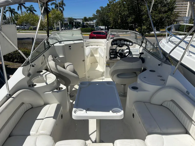 Slide: The Image of 2003 Stingray 240 LR boat interior with seating, table, and steering console. - 5