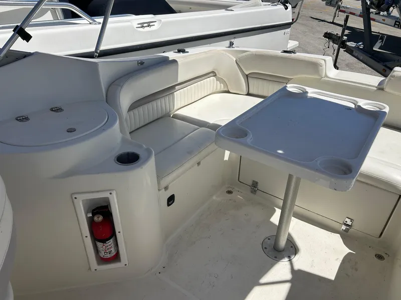Slide: The Image of 2003 Stingray 240 LR boat interior with seating and table setup. - 8