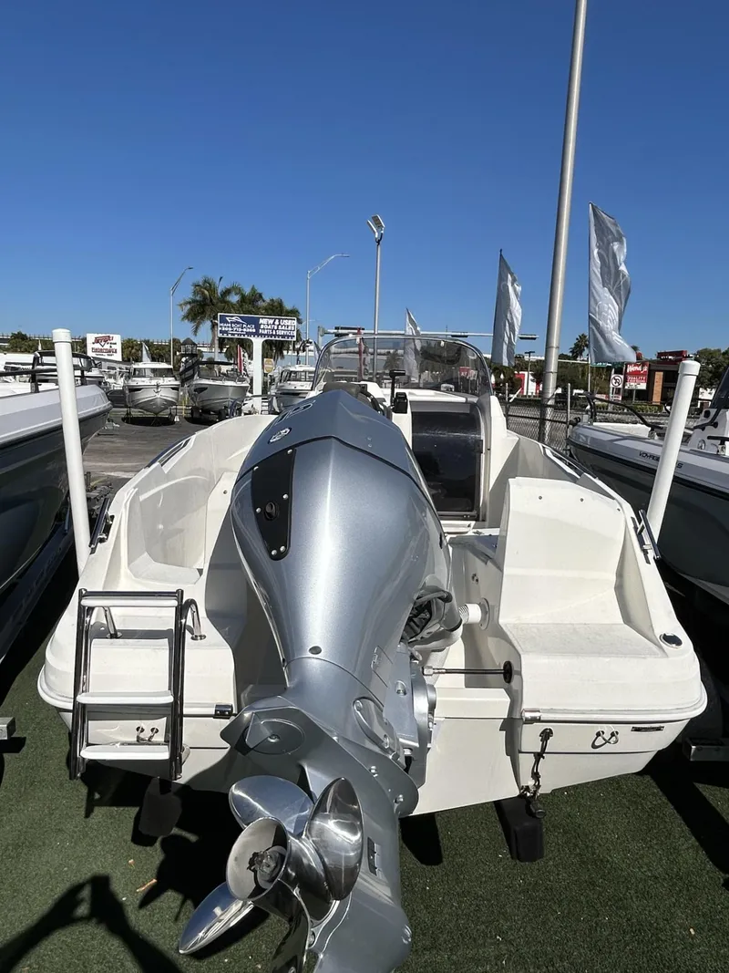 Slide: The Image of 2022 Hussar AM-555 boat with outboard motor, displayed outdoors under clear blue sky. - 3