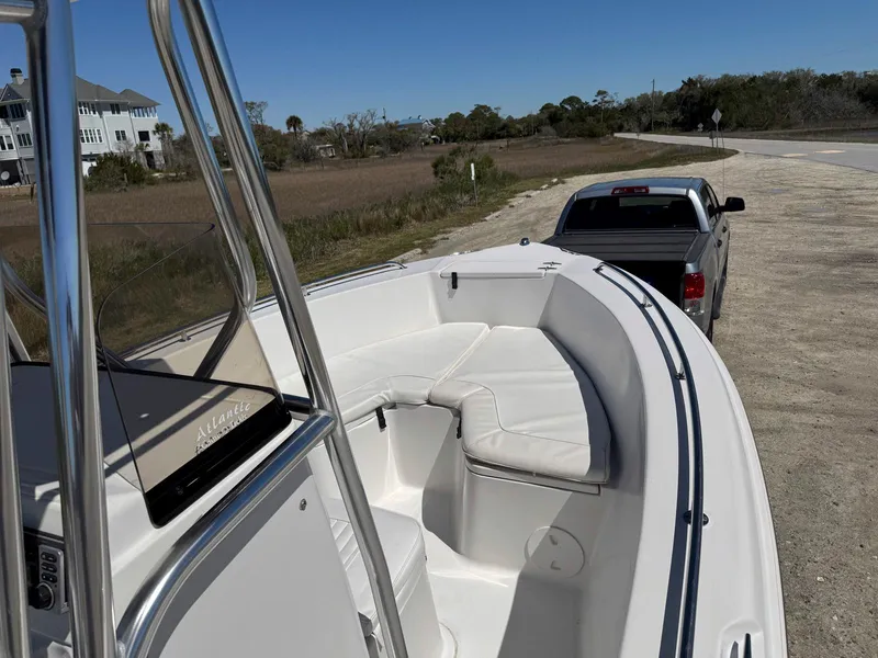 Slide: The Image of 2009 Sea Hunt Triton 220 boat on trailer, parked near a road with a pickup truck. - 11