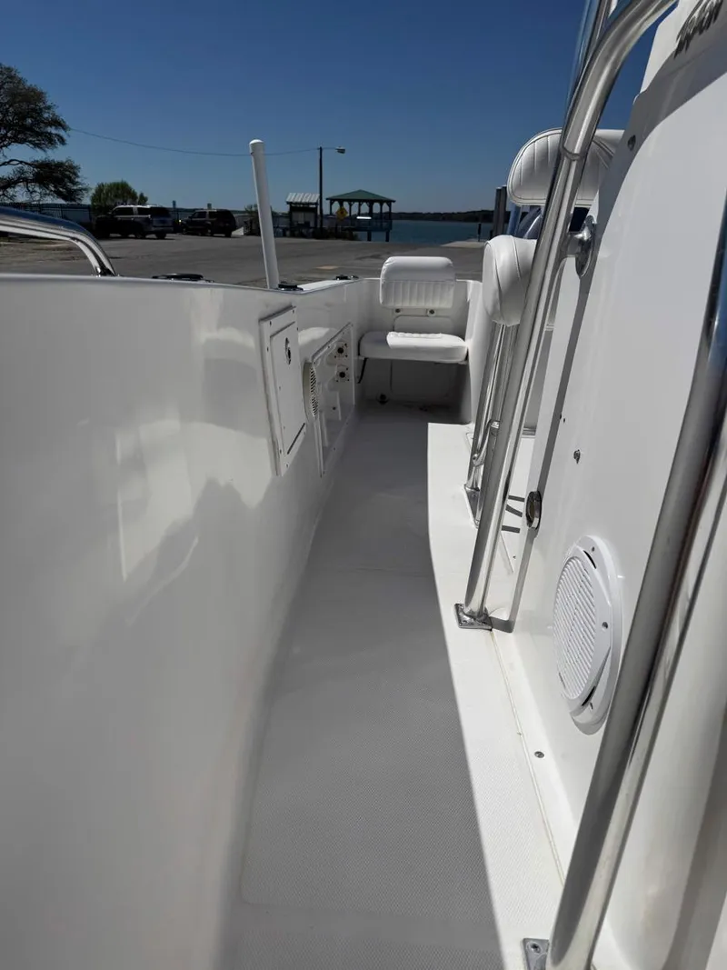 Slide: The Image of 2009 Sea Hunt Triton 220 boat deck, featuring white seating and storage compartments. - 12