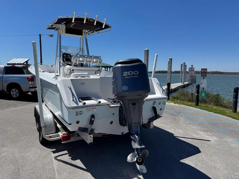 Slide: The Image of 2009 Sea Hunt Triton 220 boat with Yamaha 200 outboard motor on trailer by the water. - 3