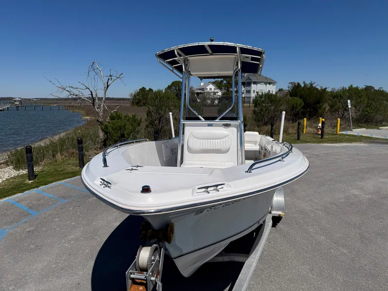 Slide: The Image of 2009 Sea Hunt Triton 220 boat on trailer near waterfront, clear sky background. - 5