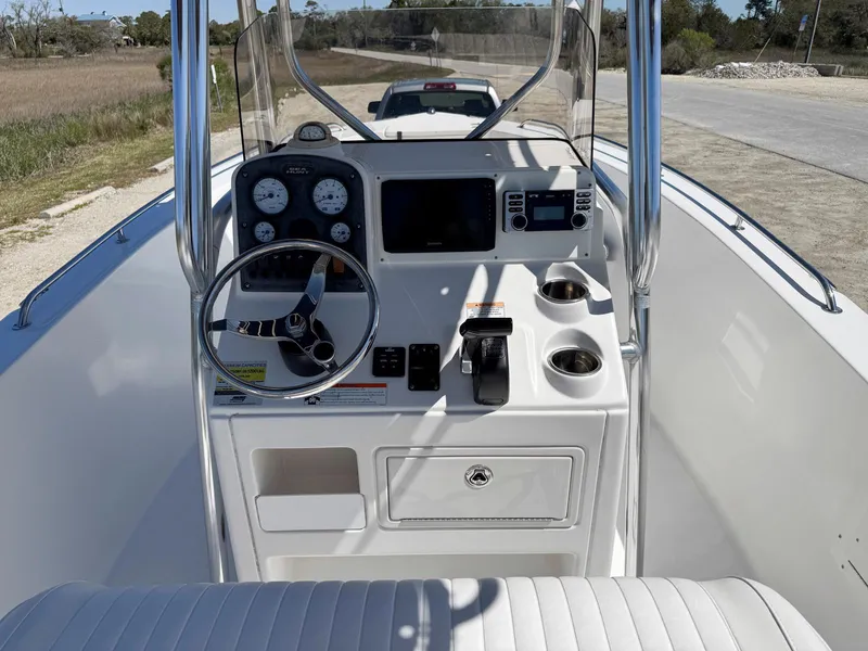 Slide: The Image of 2009 Sea Hunt Triton 220 boat console with steering wheel and navigation instruments. - 9
