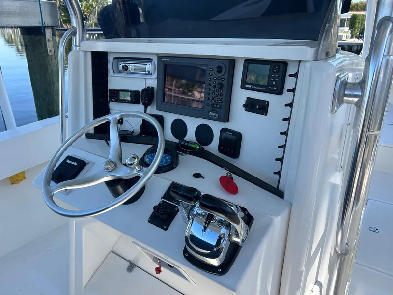 Slide: The Image of 2002 Venture 34 Center Console boat dashboard with steering wheel and navigation equipment. - 14