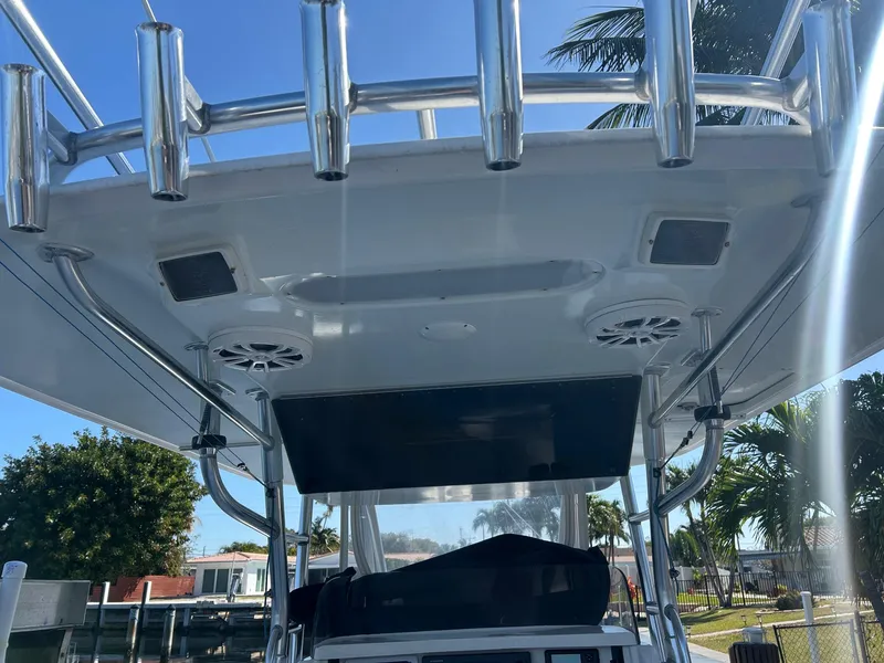 Slide: The Image of 2002 Venture 34 Center Console boat with rod holders and speakers under a clear blue sky. - 15