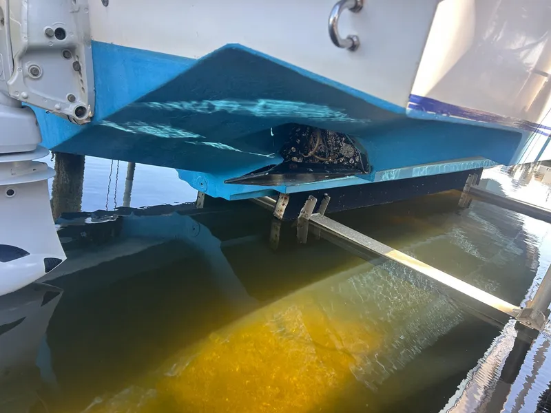 Slide: The Image of 2002 Venture 34 Center Console boat hull above water on lift. - 23