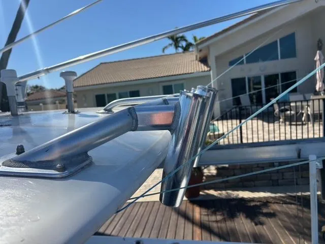 Slide: The Image of 2002 Venture 34 Center Console boat with stainless steel rod holder, docked near a house. - 25