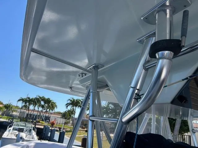Slide: The Image of 2002 Venture 34 Center Console boat with stainless steel fittings and canopy, docked near palm trees. - 26