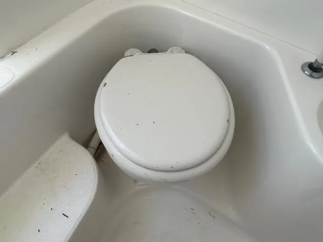 Slide: The Image of Boat toilet in 2002 Venture 34 Center Console, white and compact design. - 29