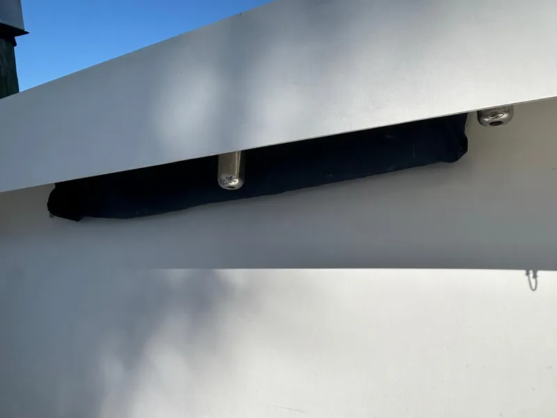 Slide: The Image of 2002 Venture 34 Center Console boat detail with rod holder and shadow on white surface. - 34