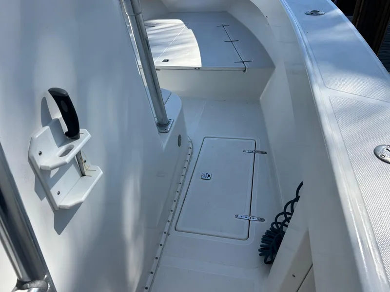 Slide: The Image of 2002 Venture 34 Center Console boat interior with storage hatch and seating area. - 37