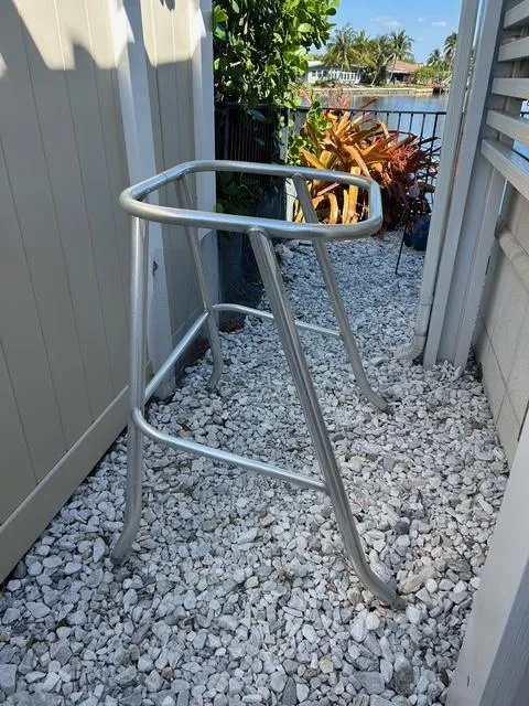 Slide: The Image of Aluminum frame on gravel path near water, surrounded by plants. - 43