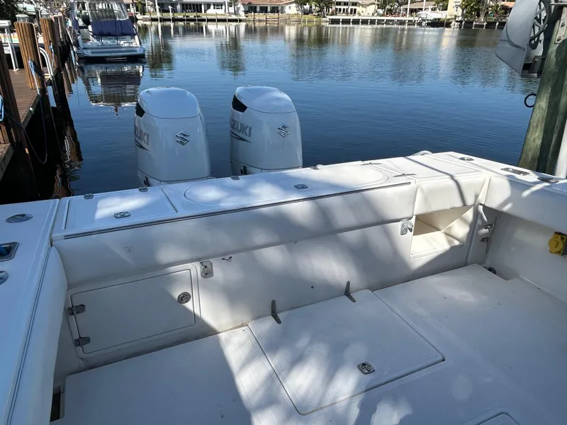 Slide: The Image of 2002 Venture 34 Center Console boat with twin Suzuki engines docked by the water. - 5