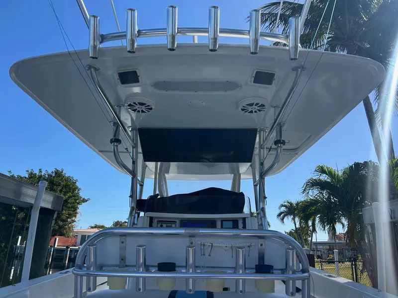 Slide: The Image of 2002 Venture 34 Center Console boat with T-top and rod holders, under clear blue sky. - 8