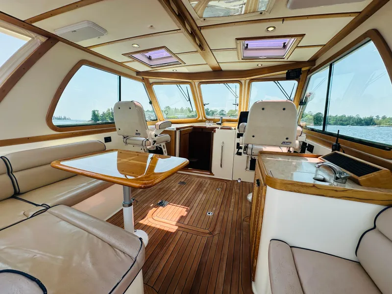 Slide: The Image of 2008 Sabre 42 Hardtop Express interior with wood flooring and seating, featuring large windows. - 11