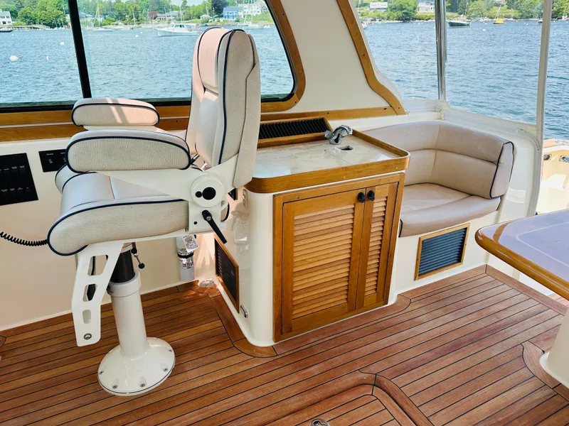 Slide: The Image of 2008 Sabre 42 Hardtop Express interior with helm seat, wooden cabinetry, and waterfront view. - 18