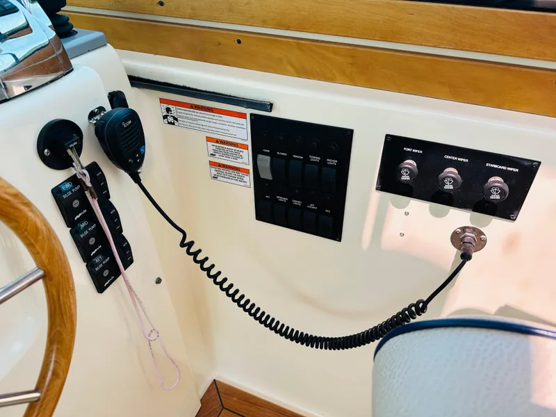 Slide: The Image of Control panel of a 2008 Sabre 42 Hardtop Express boat with switches and radio. - 19