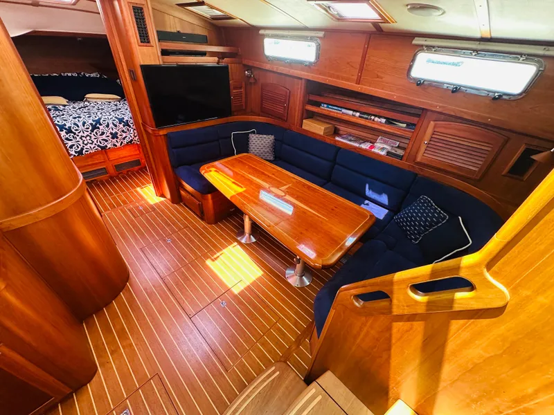 Slide: The Image of 2008 Sabre 42 Hardtop Express interior with wooden flooring, blue seating, and dining table. - 24