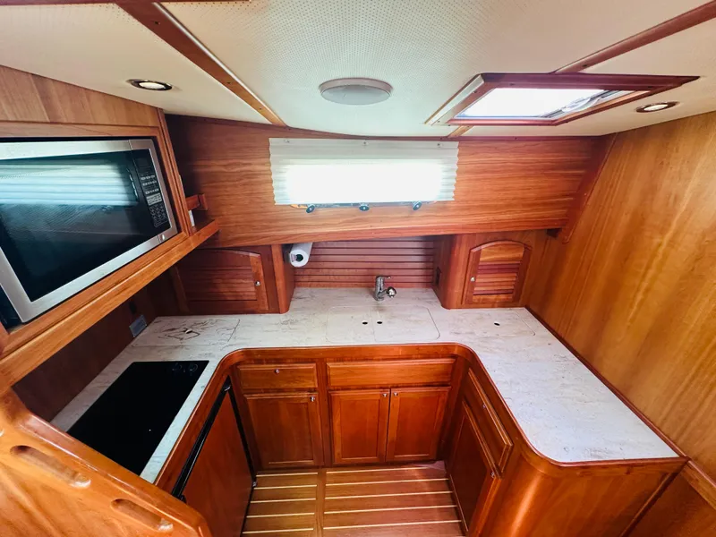 Slide: The Image of 2008 Sabre 42 Hardtop Express galley with wood cabinetry, countertop, and built-in microwave. - 28