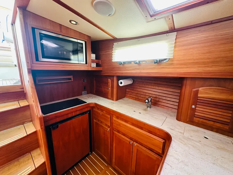 Slide: The Image of 2008 Sabre 42 Hardtop Express galley with wood cabinetry, microwave, and compact fridge. - 29