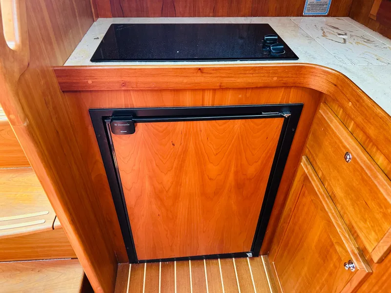Slide: The Image of 2008 Sabre 42 Hardtop Express galley with wood cabinetry and compact refrigerator. - 31
