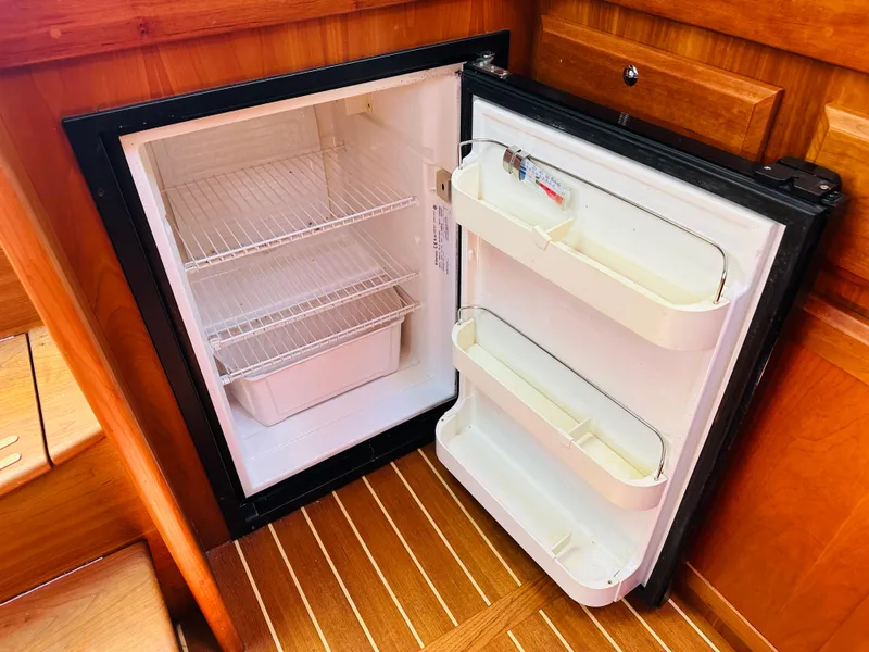 Slide: The Image of Open refrigerator inside 2008 Sabre 42 Hardtop Express yacht, featuring wooden interior. - 33