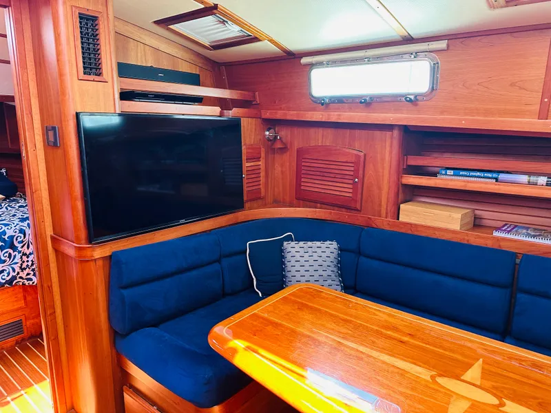 Slide: The Image of Interior of 2008 Sabre 42 Hardtop Express with blue seating, wooden table, and TV. - 36