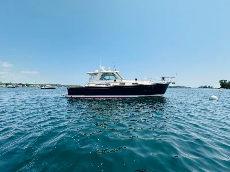 Slide: The Image of 2008 Sabre 42 Hardtop Express yacht on calm blue water under clear sky. - 4
