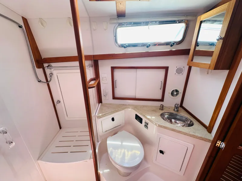 Slide: The Image of 2008 Sabre 42 Hardtop Express bathroom with shower, sink, and toilet, featuring wood accents. - 45