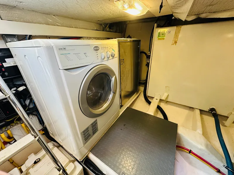 Slide: The Image of Laundry area inside 2008 Sabre 42 Hardtop Express yacht, featuring a washing machine. - 49