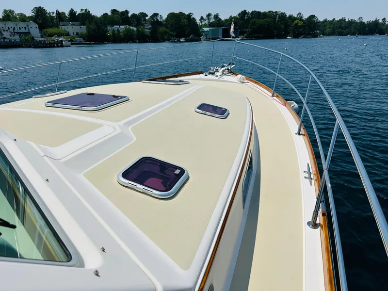 Slide: The Image of 2008 Sabre 42 Hardtop Express yacht deck with hatches, cruising on a serene lake. - 7