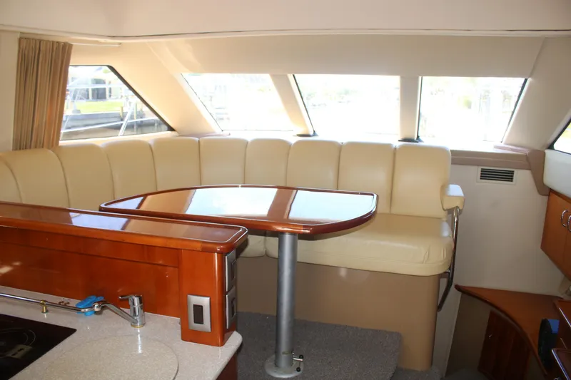 Slide: The Image of Interior of 2004 Carver 360 Sport Sedan with beige seating and wooden table. - 12