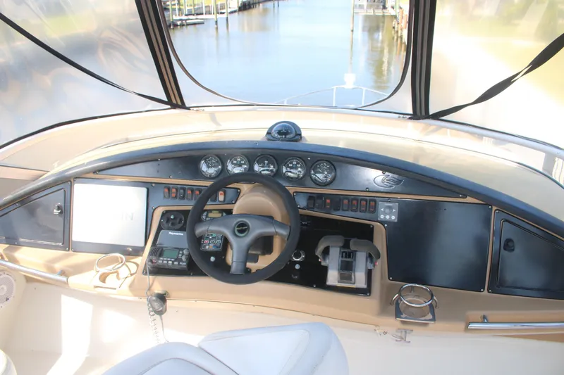 Slide: The Image of 2004 Carver 360 Sport Sedan helm with steering wheel and control panel, dock view. - 24