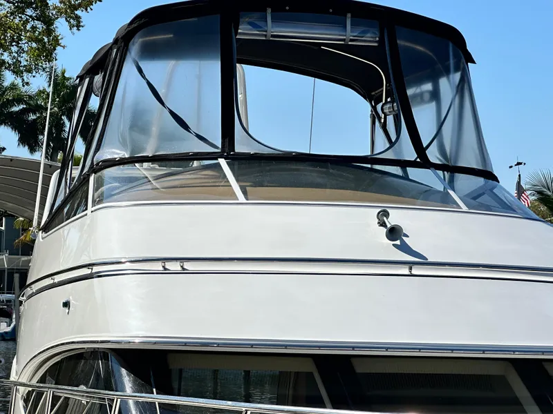 Slide: The Image of 2004 Carver 360 Sport Sedan yacht with sleek design and clear windows, docked under blue sky. - 5