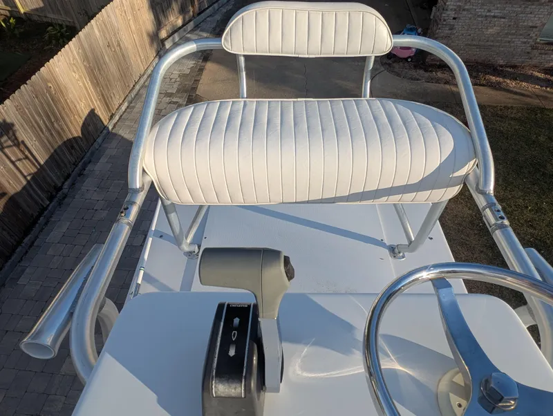 Slide: The Image of 2003 Pro-Line 22 Sport boat helm with white cushioned seat and steering wheel. - 27