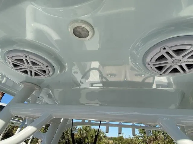 Slide: The Image of 2020 Sportsman Open 242 boat speakers and light on the ceiling, with palm trees in the background. - 20
