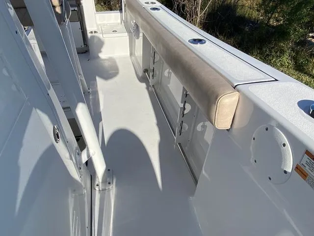 Slide: The Image of 2020 Sportsman Open 242 boat interior with cushioned seating and rod holders. - 23