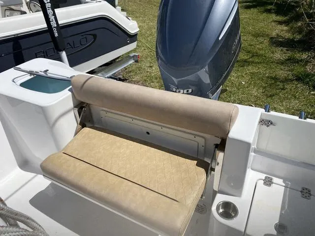 Slide: The Image of 2020 Sportsman Open 242 boat with cushioned seating and outboard motor. - 27