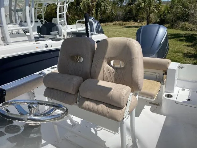 Slide: The Image of 2020 Sportsman Open 242 boat with beige cushioned seats and steering wheel. - 28