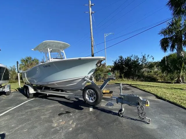 Slide: The Image of 2020 Sportsman Open 242 boat on trailer, parked outdoors under clear blue sky. - 3