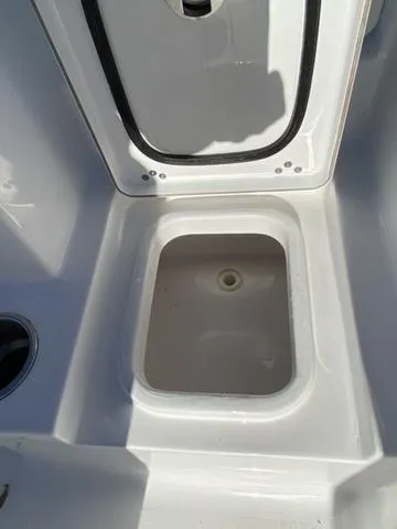 Slide: The Image of 2020 Sportsman Open 242 boat storage compartment, open lid, white interior. - 47