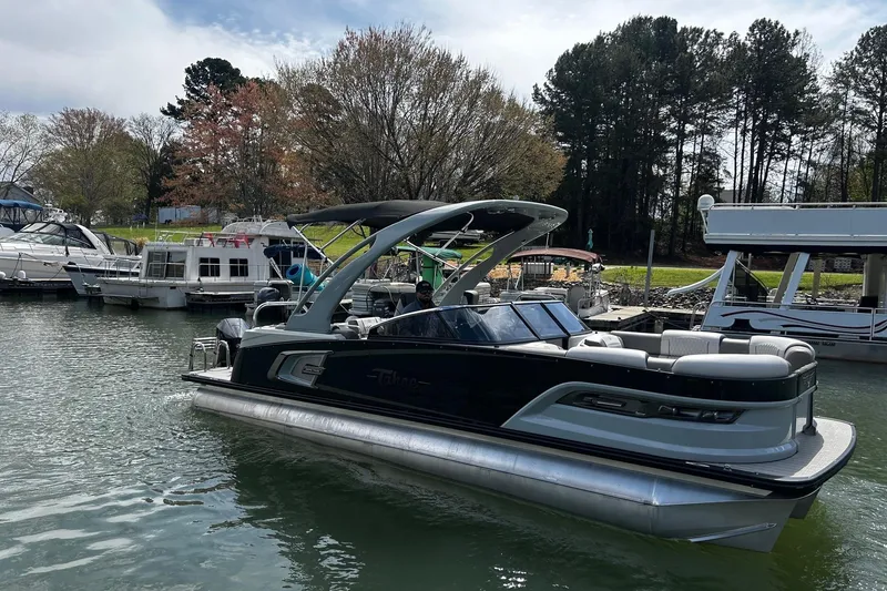 The Image of 2023 Tahoe Pontoon Grand Tahoe 25' on a serene lake with surrounding boats. - 0
