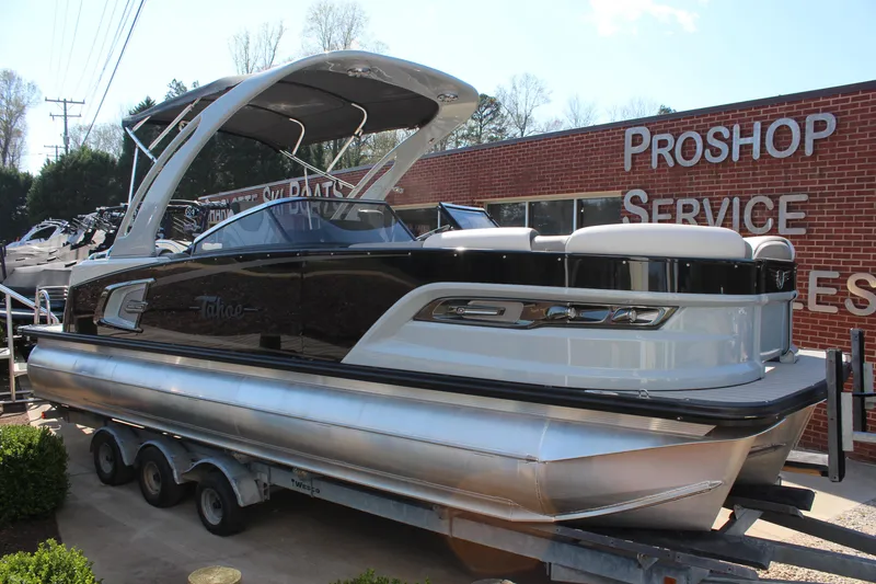 Slide: The Image of 2023 Tahoe Pontoon Grand Tahoe 25' boat on trailer outside service shop. - 16